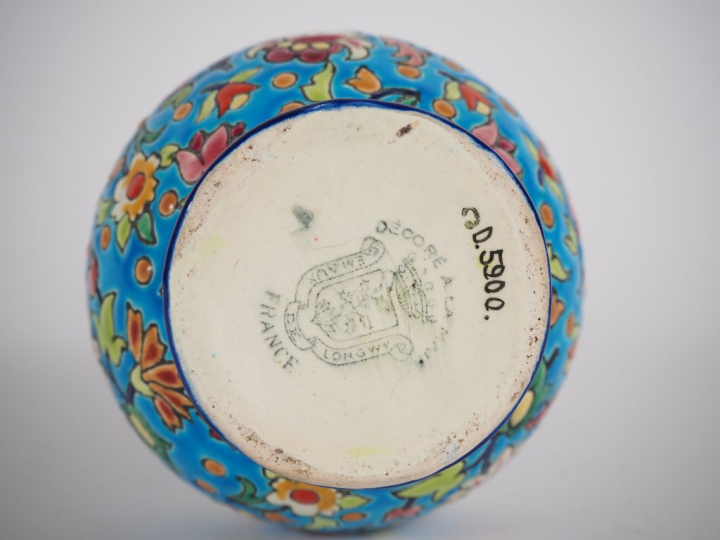 LONGWY. Vase en faïence à décor en émaux polychromes de fleurs. Signé.