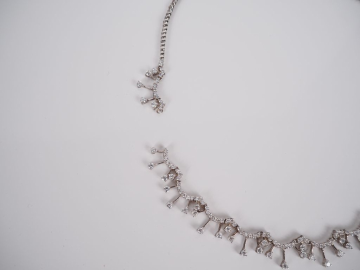 Collier draperie en argent, serti de pierres à l’imitation du diamant.