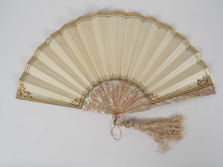 Eventail 1900 en nacre à décor d'une nymphe et d'angelots. L. 29 cm.