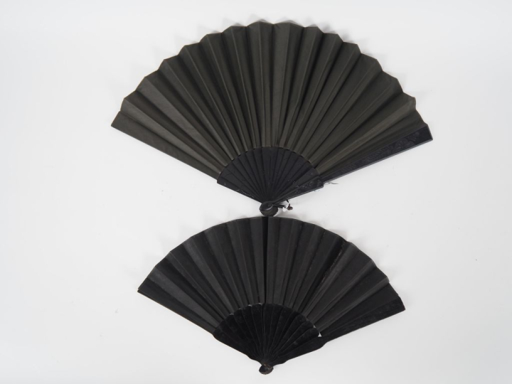 2 différents éventails en bois noirci et textile à décor de personnage
