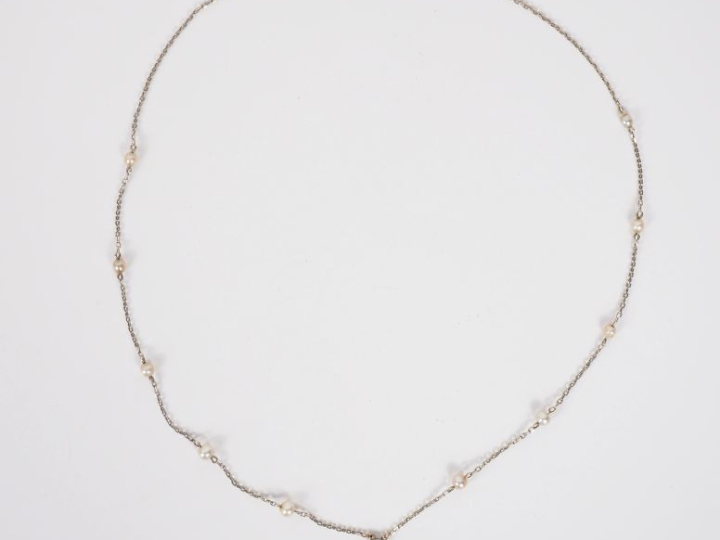 Collier en or blanc, serti en son centre d’une perle fine en forme de 