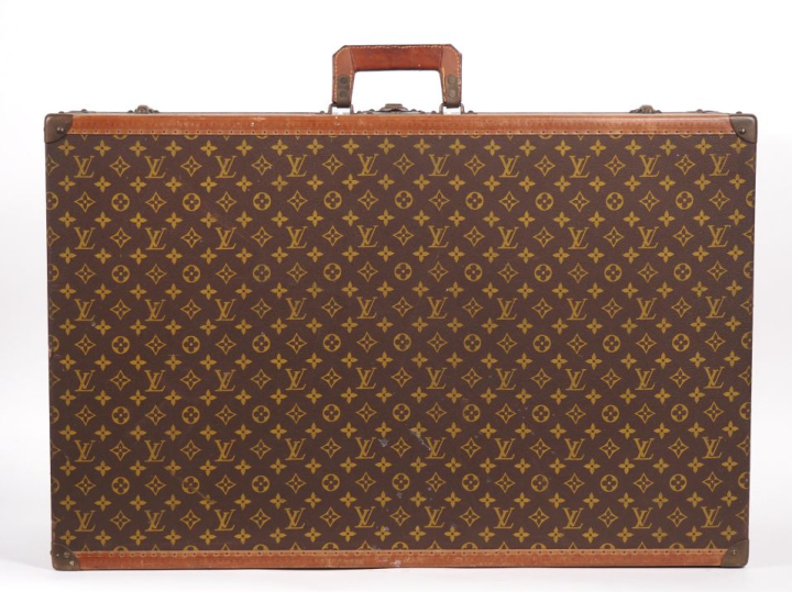 Louis VUITTON Valise rigide en toile enduite monogrammée.  Les bordure