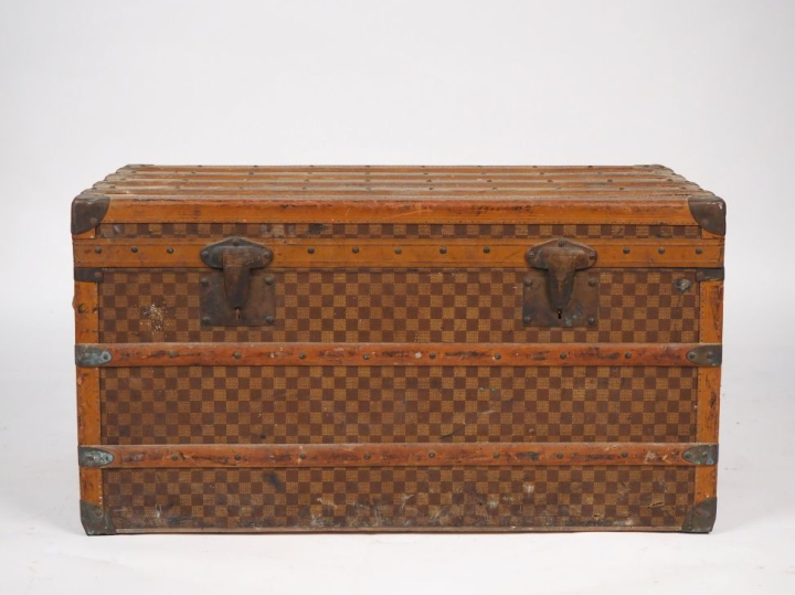 MOYNAT.  Malle de voyage en toile enduite, à décor de damier.  Poignée