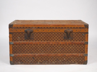 Vente aux enchères MOYNAT.  Malle de voyage en toile enduite, à décor de damier.  Poignée