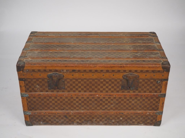 MOYNAT.  Malle de voyage en toile enduite, à décor de damier.  Poignée