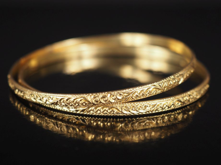 Paire de bracelets joncs en or jaune 750, à décor de rinceaux feuillag