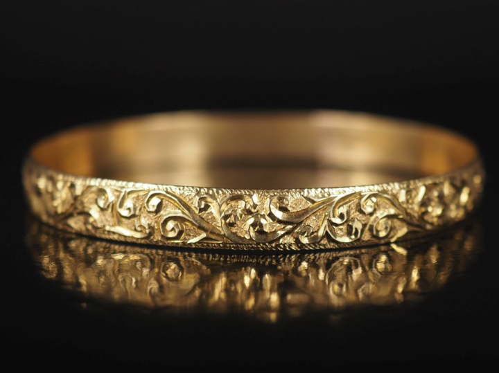 Bracelet jonc en or jaune 750, à décor de rinceaux feuillagés. Poinçon