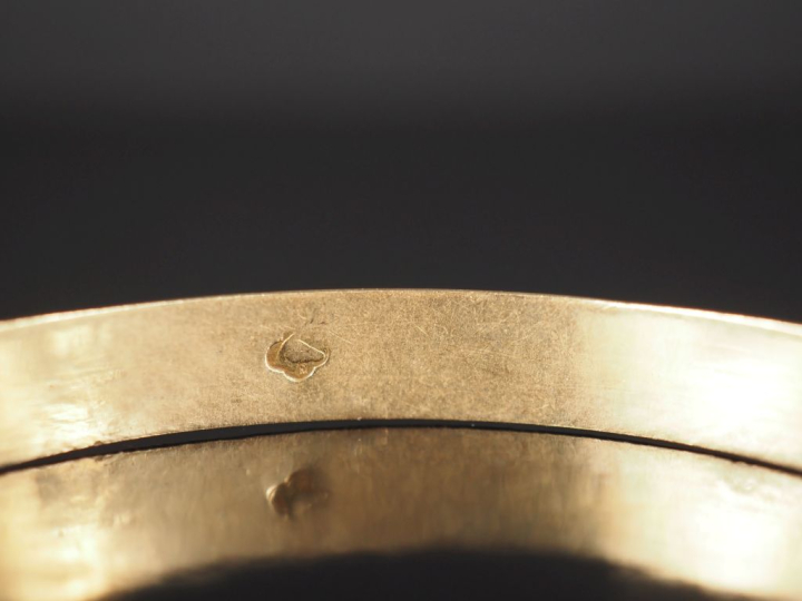 Bracelet jonc en or jaune 750, à décor de rinceaux feuillagés. Poinçon