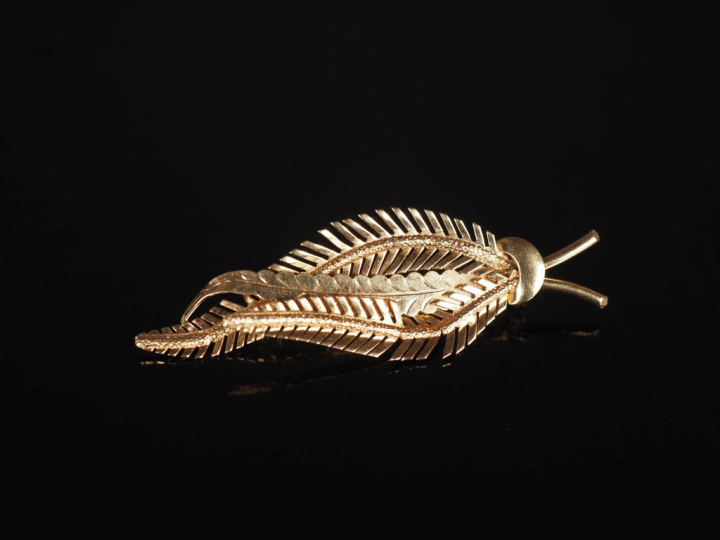 Broche en or jaune 750, en forme de feuille stylisée.  Long. 5,7 cm Po