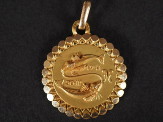 Vente aux enchères Médaillon en or jaune 750, à décor de poissons et agrémenté de dates. 