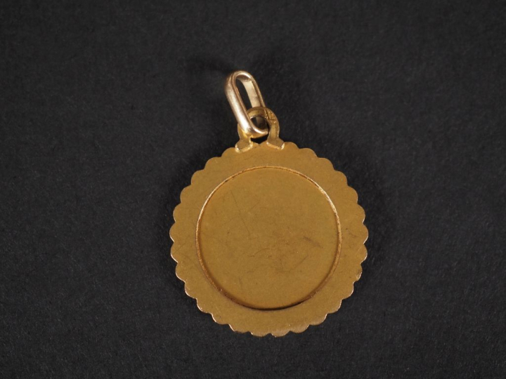 Médaillon en or jaune 750, à décor de poissons et agrémenté de dates. 