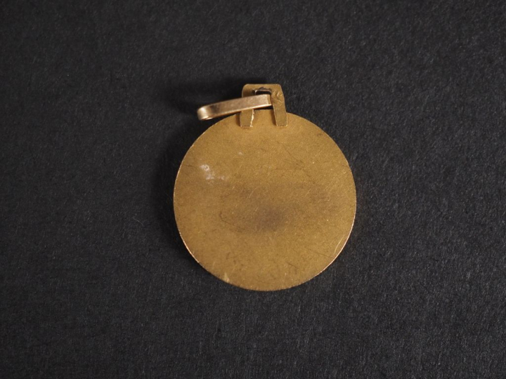 Petit médaillon en or jaune 750, figurant deux jeunes femmes assises. 