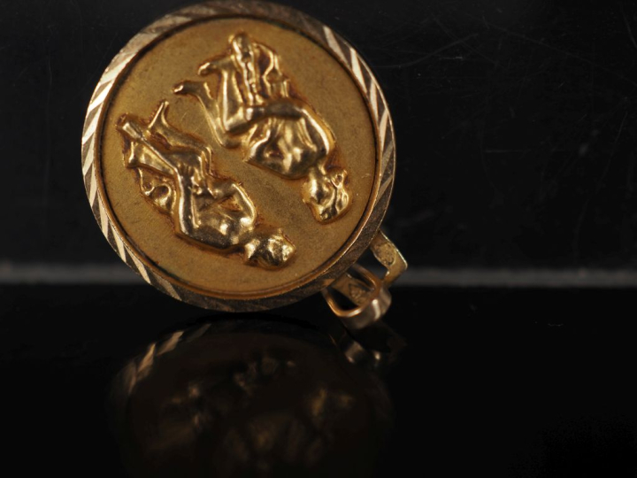 Petit médaillon en or jaune 750, figurant deux jeunes femmes assises. 