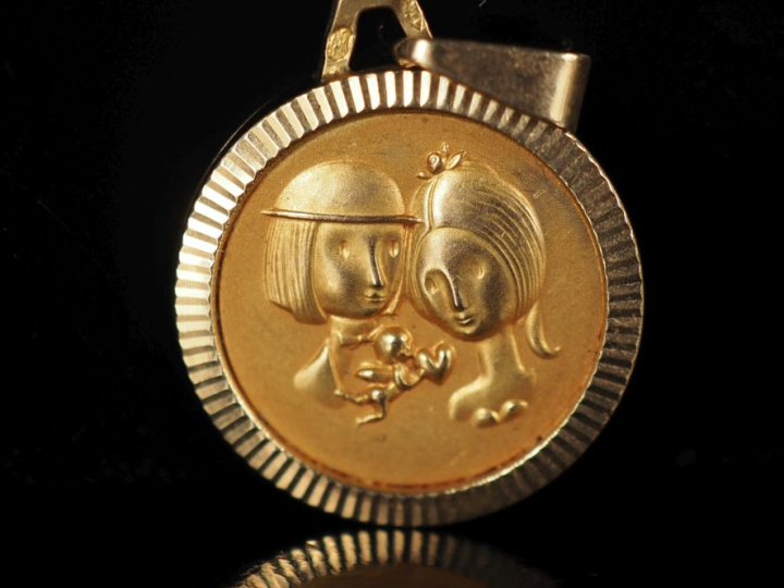 Médaille en or jaune 750, figurant un couple.  Diam. 1,5 cm Poids. 1,1
