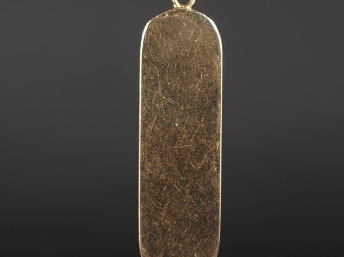 Pendentif en or jaune 750, à décor de hiéroglyphes.  H. 3,7 cm Poids. 