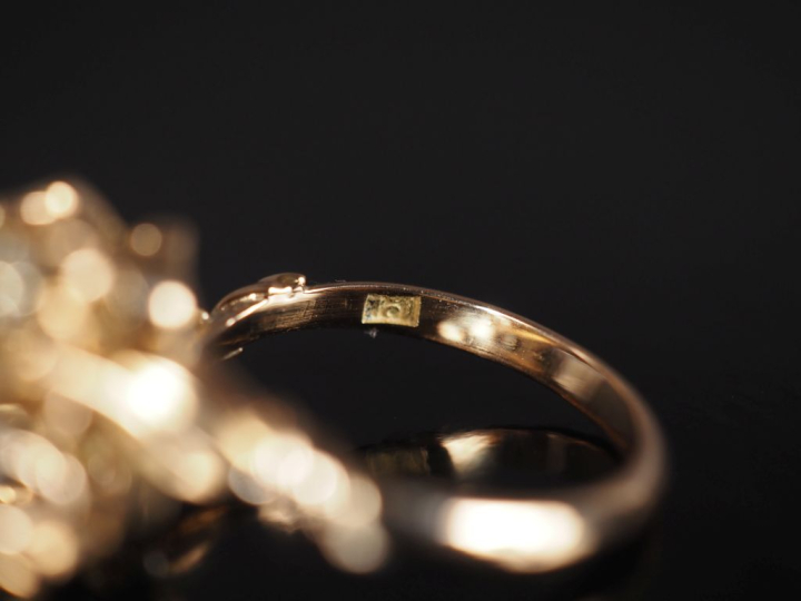 Bague à décor floral en or jaune 750, sertie de deux diamants pesant e