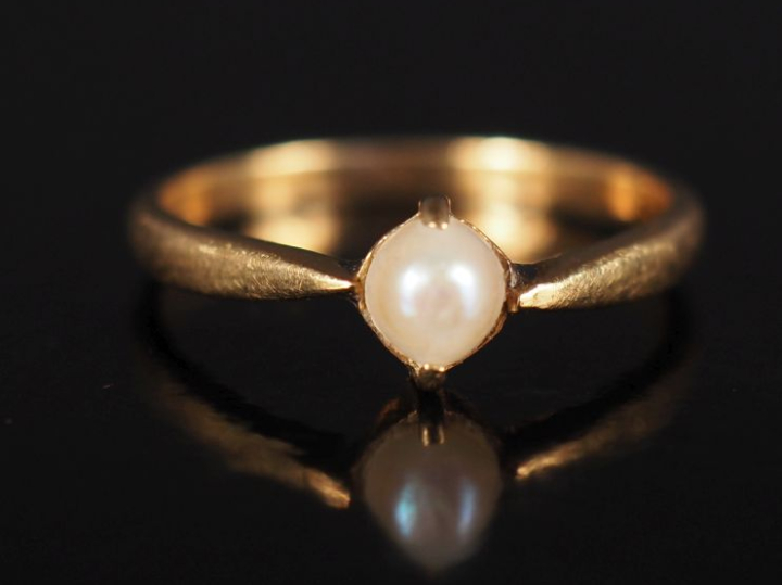 Petite bague en or jaune 750, sertie d'une demi-perle blanche. TDD. 50