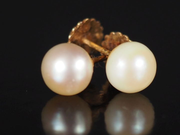 Paire de perces oreilles en or jaune 750, sertis d'une perle blanche. 