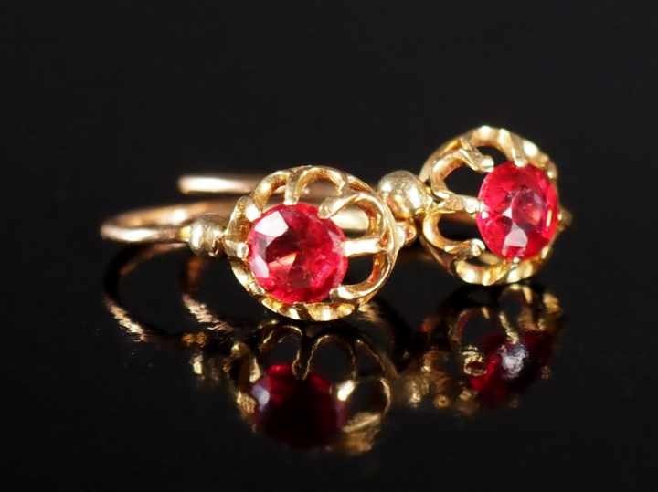 Paire de perces oreilles en or jaune 750, sertis d'une pierre rouge.  