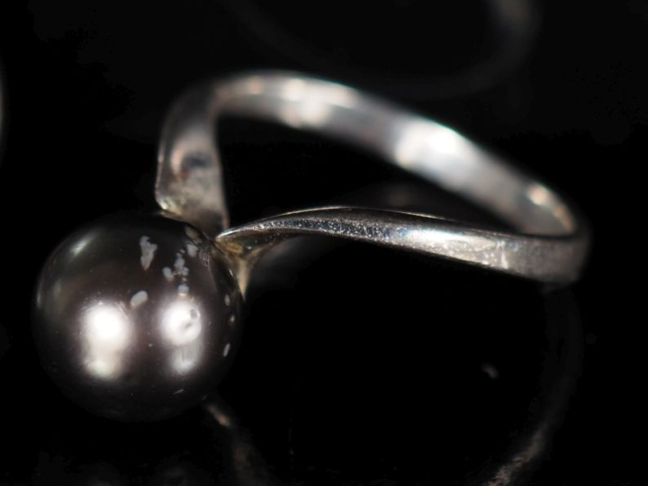 Bague en argent de forme stylisée, sertie d'une perle grise.  TDD. 51 