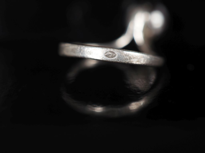 Bague en argent de forme stylisée, sertie d'une perle grise.  TDD. 51 