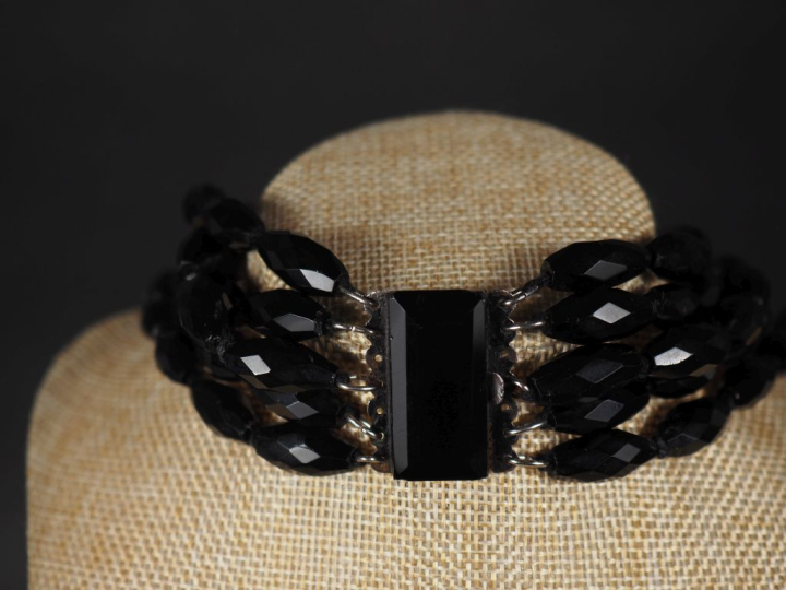 Collier draperie cinq rangs en perles de jais (?) facettées.