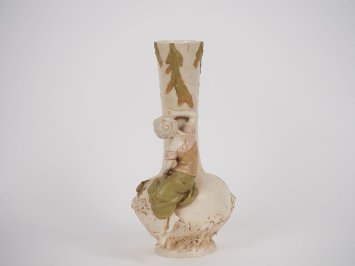 ROYAL DUX. Vase en biscuit polychrome à décor de jeune fille au crabe.