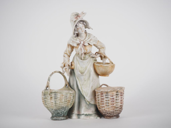 Vide poche en porcelaine polychrome figurant une jeune femme au panier