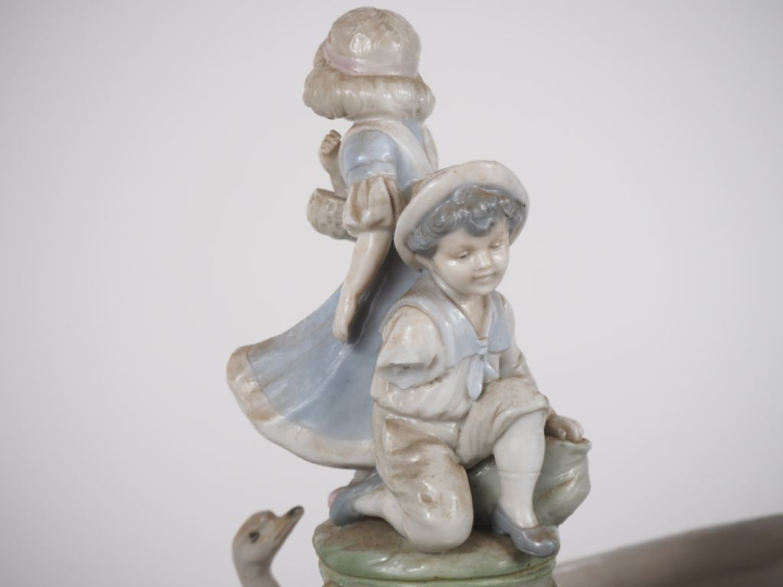 Grand vide poche en porcelaine polychrome à décor d'enfant et de cygne