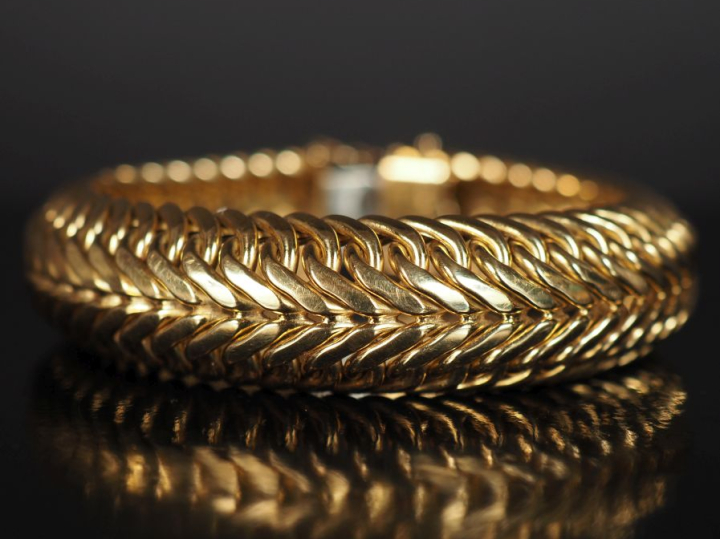 Bracelet manchette en or jaune 750, maille tressée de forme bombée.  L