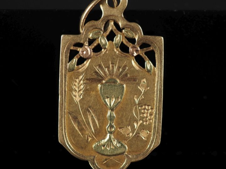 Médaille religieuse en or jaune 750, ornée en son centre d'un calice e