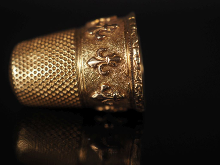 Dé à coudre en or jaune 750, à décor d'une frise de fleurs de lys. H. 