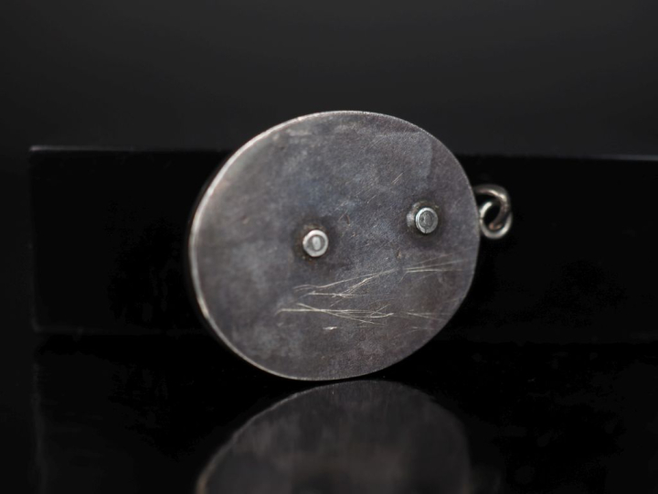 Pendentif de forme ovale en argent, serti d'onyx noir et orné de pampr