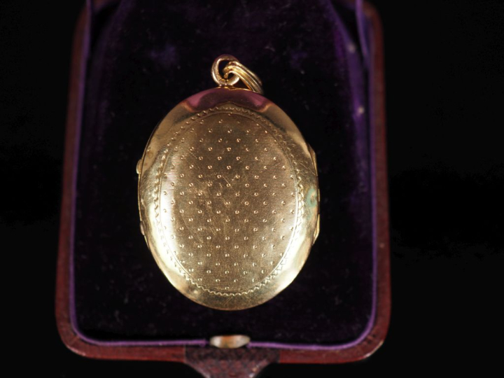 Pendentif porte-photo en or jaune 750 de forme ovale, serti en son cen