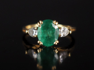 Vente aux enchères Bague en or jaune 750, serte en son centre d'une émeraude épaulée de d