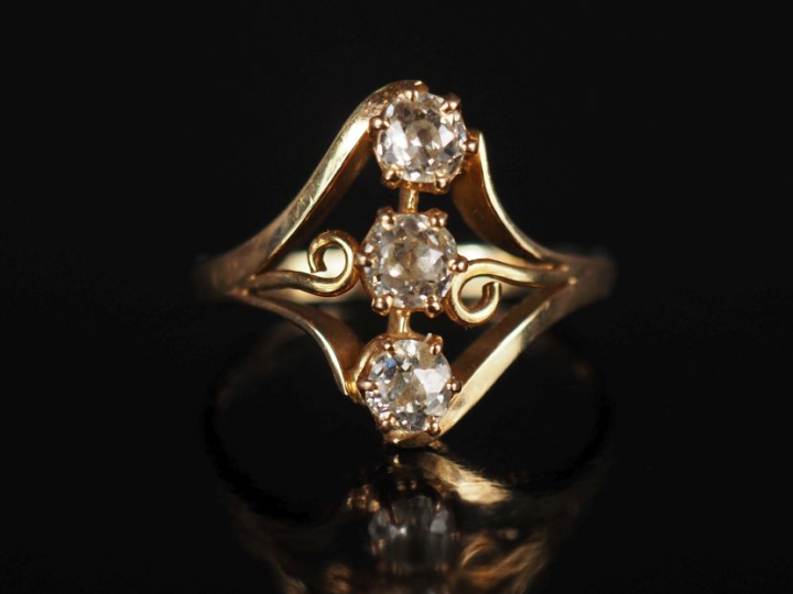 Bague de forme stylisée et ajourée en or jaune 750, sertie de trois di