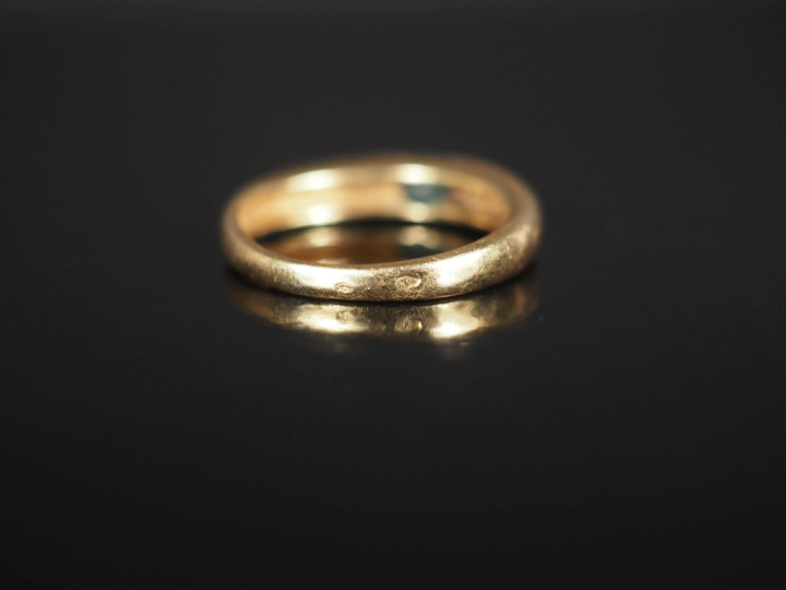 Bague jonc en or jaune 750, sertie en son centre d'une émeraude.  TDD.