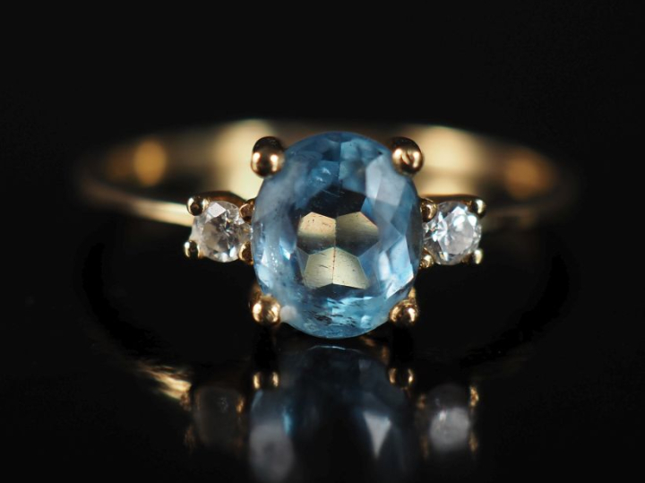Bague en or jaune 750, sertie en son centre d'une pierre bleu ciel épa