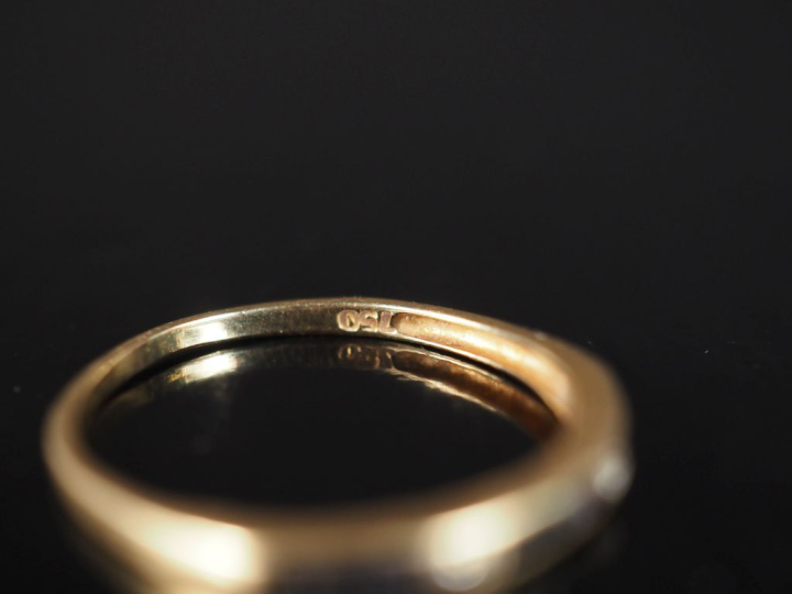 Demi alliance en or jaune 750, sertie de saphirs calibrées et deux pet