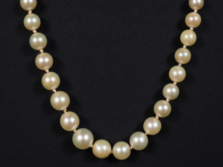 Collier de perles blanches disposées en chute.  Joli fermoir en or jau