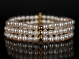 Vente aux enchères Bracelet souple triple rangs de perles agrémenté de trois maillons en 