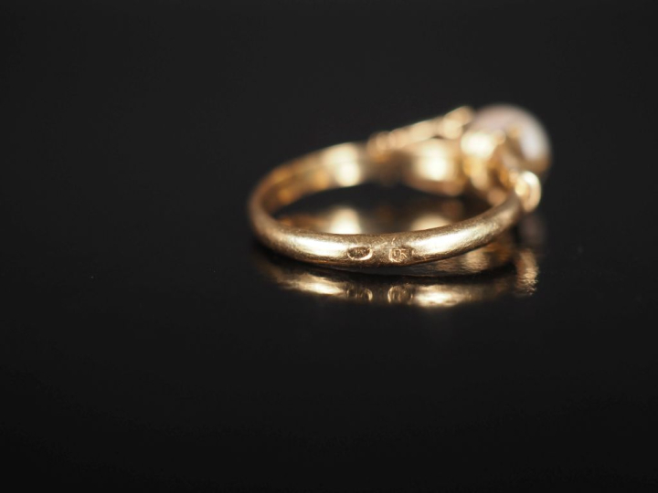 Bague en or jaune 750, sertie en son centre d'une perle blanche. Attac