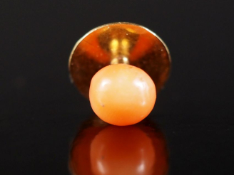 Vente aux enchères Bouton de col en or jaune 750, serti de corail en cabochon.  Poids tel