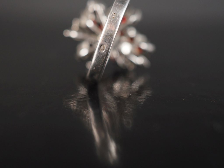 Bague à motif floral en argent, sertie de pierres rouges.  TDD. 57 Poi