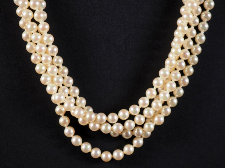 Collier de perles blanches quatre rangs. Jolie fermoir en métal doré, 