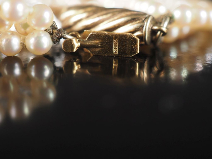 Collier de perles blanches quatre rangs. Jolie fermoir en métal doré, 