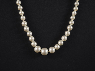 Vente aux enchères Collier de perles blanches disposées en chute.  Fermoir en métal doré.