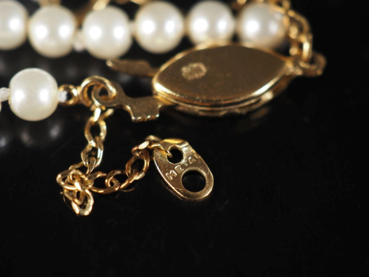 Collier de perles blanches disposées en chute.  Fermoir en métal doré.