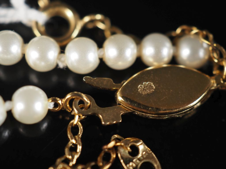 Collier de perles blanches disposées en chute.  Fermoir en métal doré.