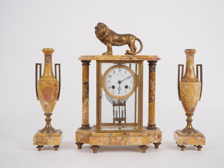 Garniture de cheminée en marbre et laiton comprenant une pendule porti